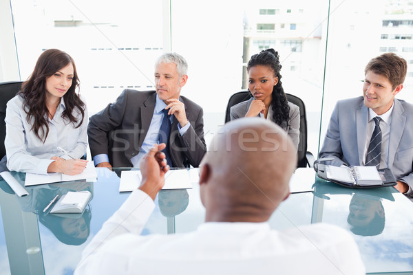 Stock photo: A manager and an employee communicating during a meeting with the full team