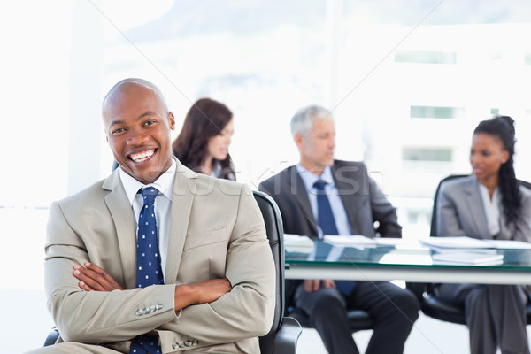 Young executive laughing while crossing his arms and sitting in front of his team Stock photo © wavebreak_media