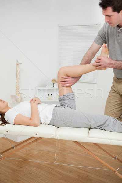 Serious osteopath bending the leg of a woman in a room Stock photo © wavebreak_media