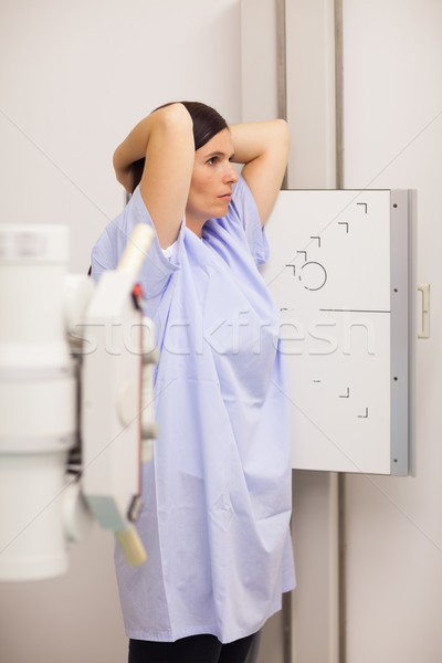 Woman placing her arms on her head while standing in front of a machine in an examination room Stock photo © wavebreak_media