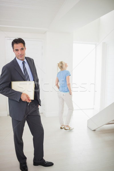 Well dressed real estate agent with blurred woman in background Stock photo © wavebreak_media