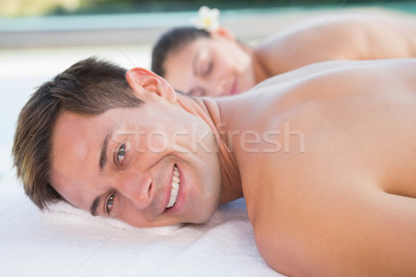 Stock photo: Attractive couple enjoying hot stone massage poolside
