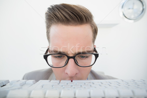 Nerdy businessman looking at keyboard Stock photo © wavebreak_media