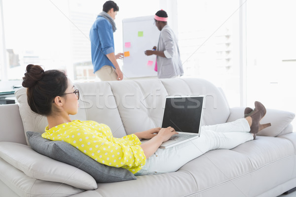 Young creative woman using laptop on couch Stock photo © wavebreak_media