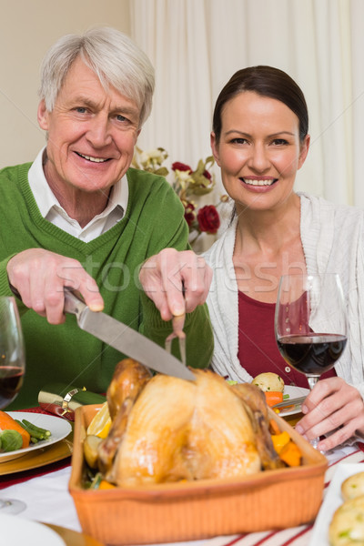 Grandfather carving chicken while woman drinking red wine Stock photo © wavebreak_media