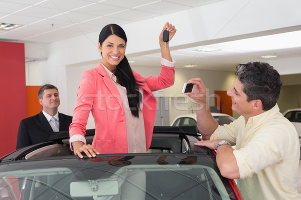 Woman standing in red cabriolet and man taking picture Stock photo © wavebreak_media