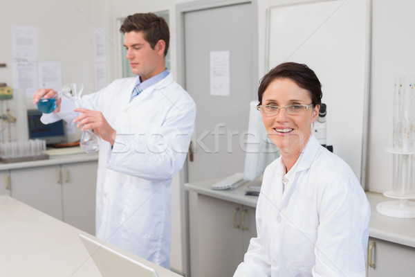 Stock photo: Scientist working attentively with laptop and another with beake