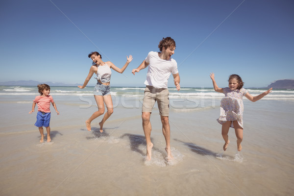 Vrolijk familie springen wal strand blauwe hemel Stockfoto © wavebreak_media