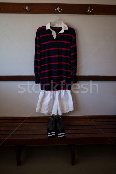 Shoes and socks on wooden bench against rugby uniform Stock photo © wavebreak_media