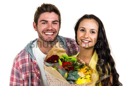 Smiling woman holding bouquet and being kissed by boyfriend Stock photo © wavebreak_media