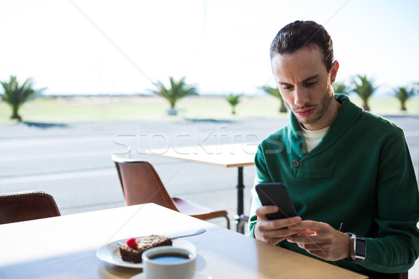 Stockfoto: Man · mobiele · telefoon · cake · beker · lage · tafel · cafetaria