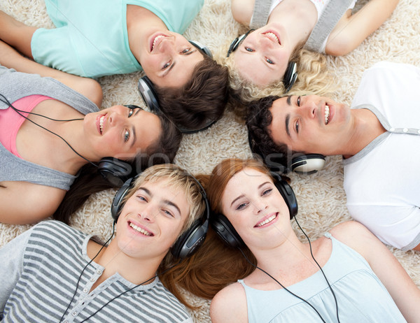 Group of friends listening to music on the floor Stock photo © wavebreak_media