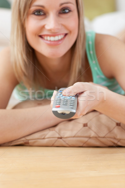 Jolly blond woman watching TV lying on the floor Stock photo © wavebreak_media