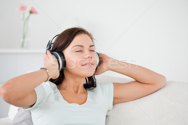 Charming dark-haired woman listening to music in her living room Stock photo © wavebreak_media