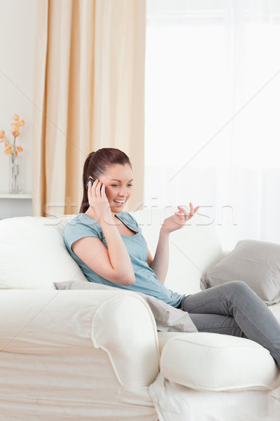 Káprázatos nő telefonál ül kanapé nappali divat Stock fotó © wavebreak_media