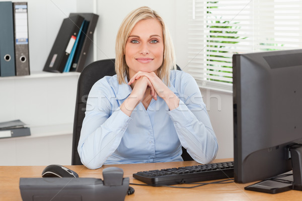 Femme souriante menton mains derrière bureau bureau [[stock_photo]] © wavebreak_media