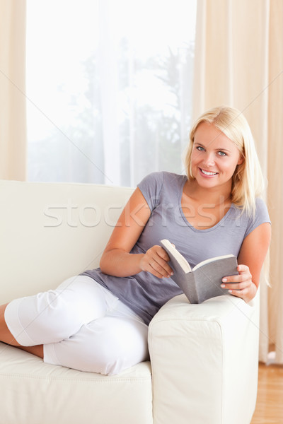 Stock photo: Portrait of a woman holding a book in her living room