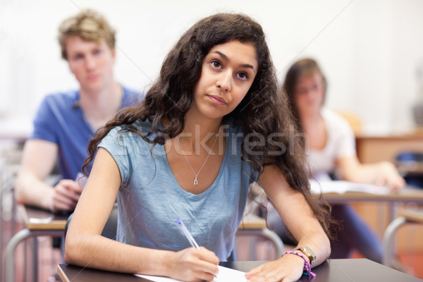 Focused student taking notes in a classroom Stock photo © wavebreak_media