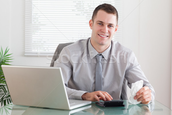Stock photo: Smiling young businessman checking an invoice