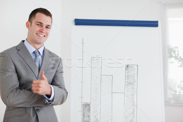 Smiling businessman giving thumb up next to diagram Stock photo © wavebreak_media