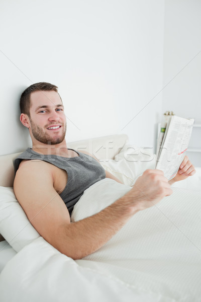 Сток-фото: портрет · улыбаясь · человека · чтение · газета · спальня