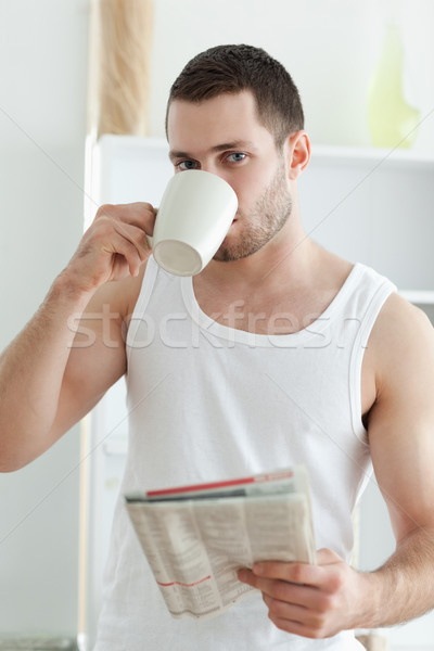 Portrait of a handsome man drinking tea while reading the news in his kitchen Stock photo © wavebreak_media