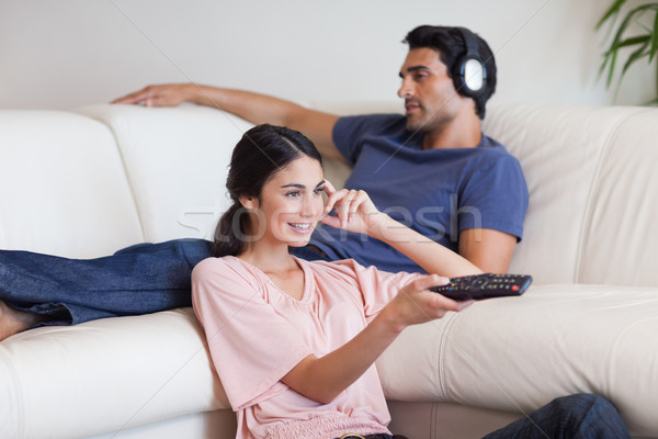 Mujer viendo tv amigo escuchar música salón Foto stock © wavebreak_media