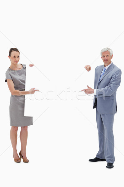 White hair businessman holding and pointing to a big white sign with a woman against white backgroun Stock photo © wavebreak_media