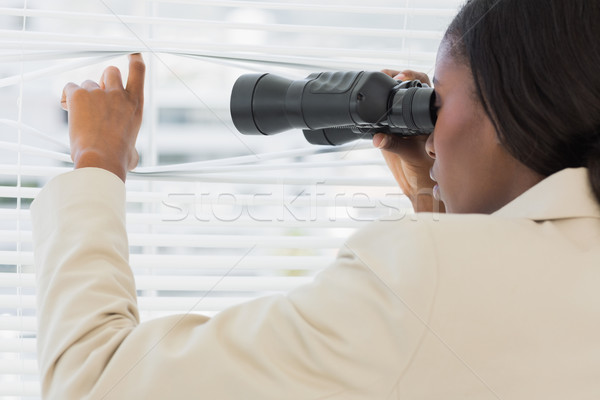 Businesswoman peeking with binoculars through blinds Stock photo © wavebreak_media