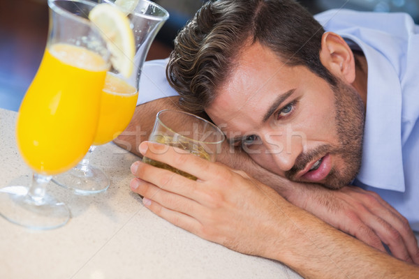 Drunk businessman slumped on bar beside cocktail Stock photo © wavebreak_media