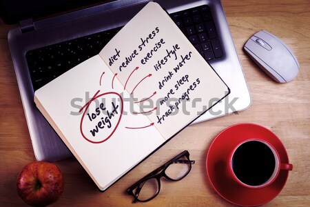 Overhead of open notebook on laptop Stock photo © wavebreak_media
