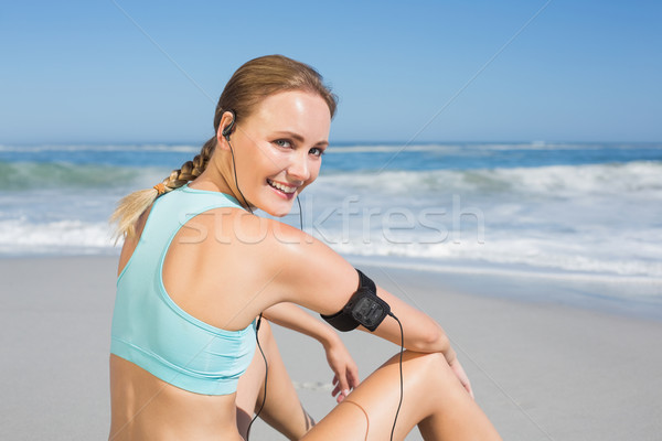 Fit woman sitting on the beach taking a break smiling at camera Stock photo © wavebreak_media
