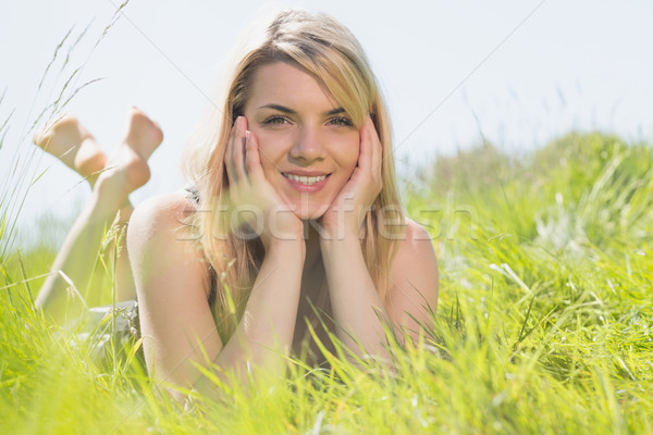 Stock photo: Pretty blonde in sundress lying on grass smiling at camera
