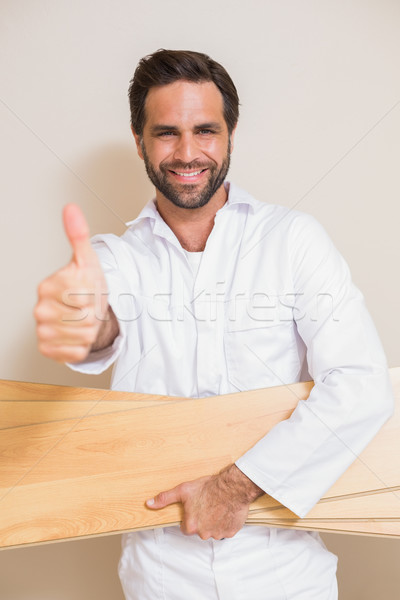 Carpenter holding planks showing thumbs up Stock photo © wavebreak_media