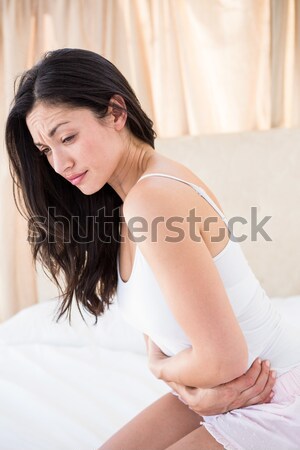 Dość brunetka żołądka ból bed domu Zdjęcia stock © wavebreak_media
