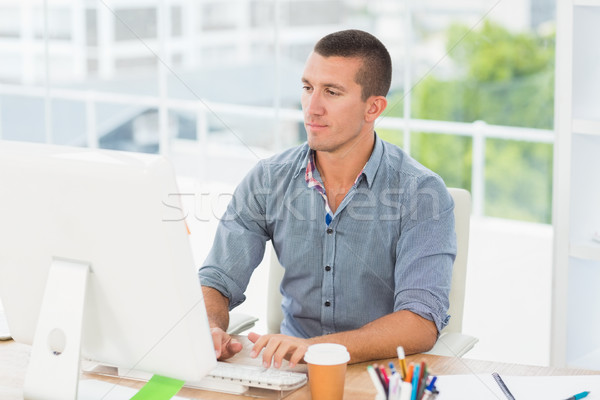 Stock photo: Handsome businessman typing on a computer