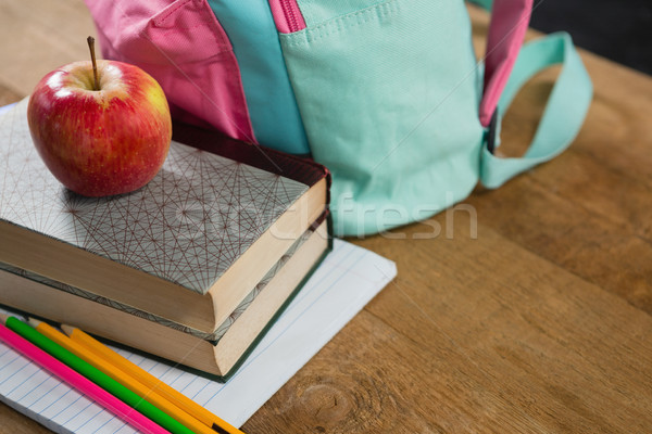 Stock photo: Apple on stack of books with schoolbag