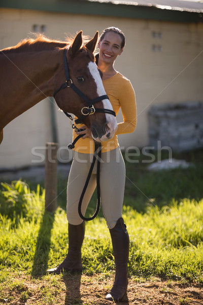 Kobiet jockey stałego konia dziedzinie stodoła Zdjęcia stock © wavebreak_media