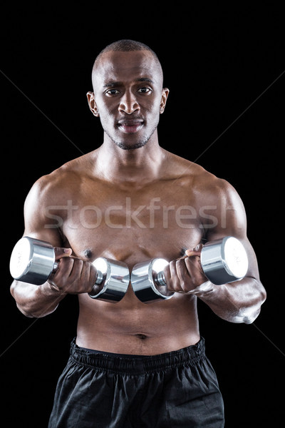 Portrait of confident athlete holding dumbbell Stock photo © wavebreak_media