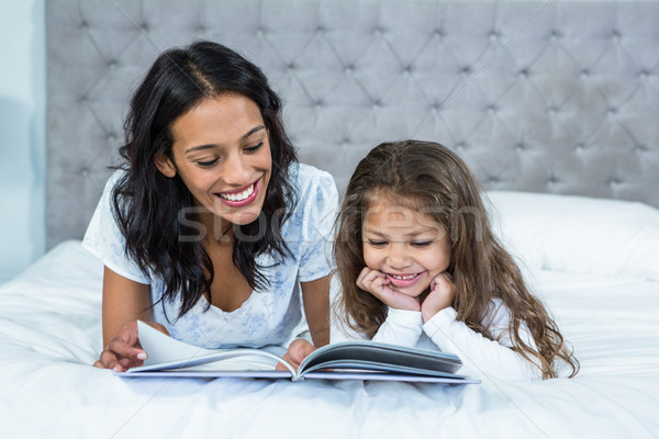 Feliz madre hija lectura libro cama Foto stock © wavebreak_media