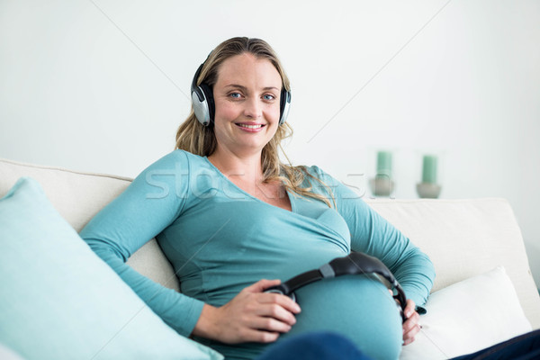Foto stock: Mujer · embarazada · escuchar · música · auriculares · vientre · sofá · mujer