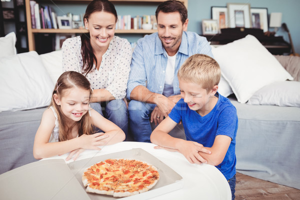 Stock photo: Smiling family with pizza on table