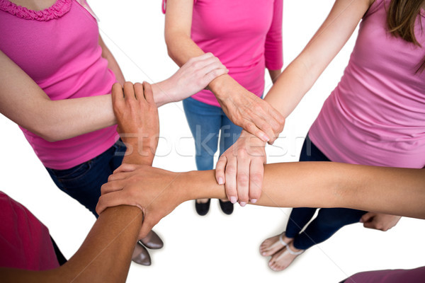 Women in pink outfits joining in a circle for breast cancer awar Stock photo © wavebreak_media