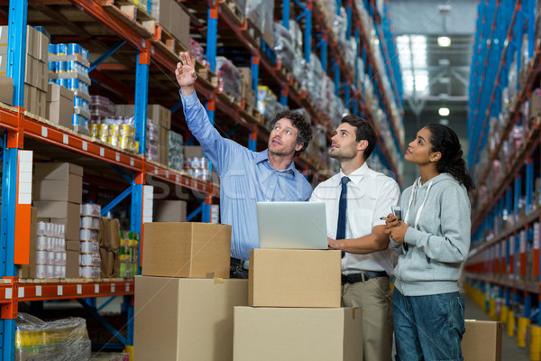 Stock photo: Worker team looking goods on a shelf 
