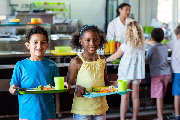 Boldog iskolás gyerekek tart étel tálca étkezde Stock fotó © wavebreak_media