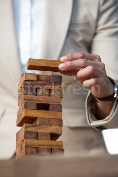 Businesswoman placing wooden block on a tower Stock photo © wavebreak_media