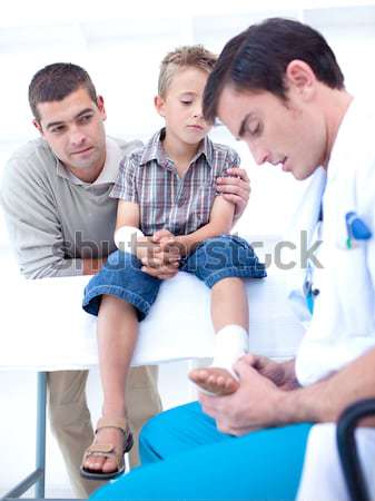Doctor tying hand band on hand of a patient Stock photo © wavebreak_media