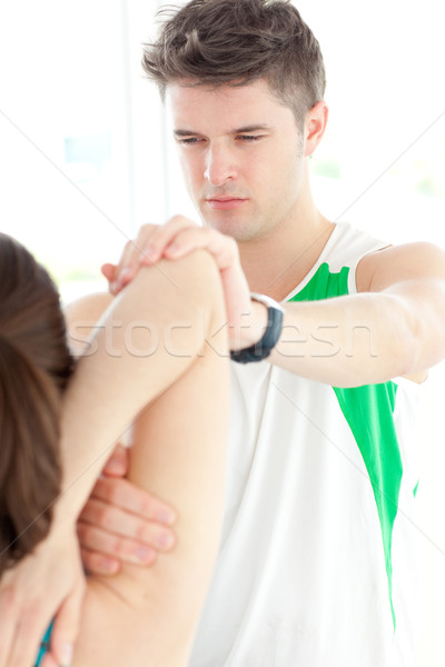Concentrated physical therapist checking a woman's shoulder Stock photo © wavebreak_media