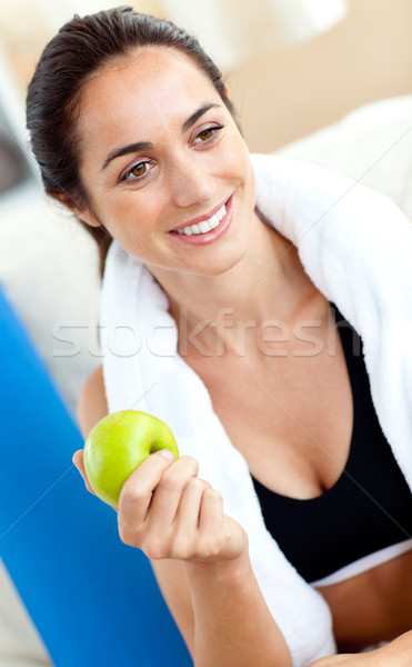 Smiling woman eating an apple on the sofa after working out in the living-room at home Stock photo © wavebreak_media