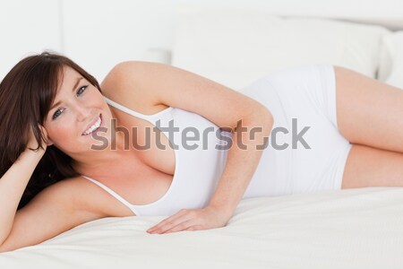 Stock photo: Pretty red-haired female having a rest while lying on her bed